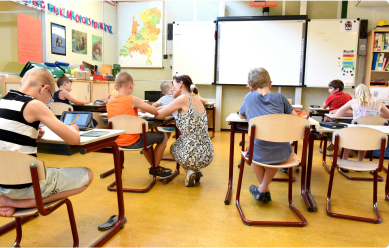 Children in a classroom raising their hands