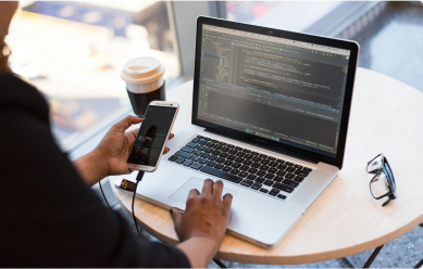 Person testing a software with their phone and laptop